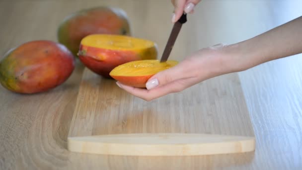 Vrouwelijke chef-koks handen slice mango op houten snijplank. — Stockvideo