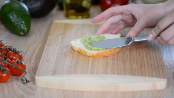 在烤面包上撒上捣碎的鳄梨健康的素食早餐. — 图库视频影像