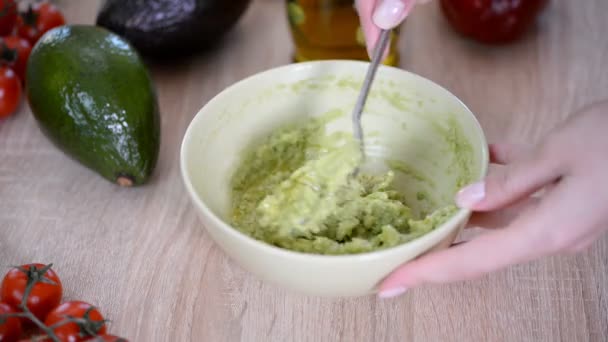 Close-up van vrouw handen Mashing avocado met vork in Bowl. — Stockvideo
