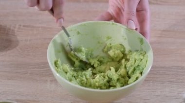Kasede Çatal ile Kadın Eller Mashing Avokado Close-up.