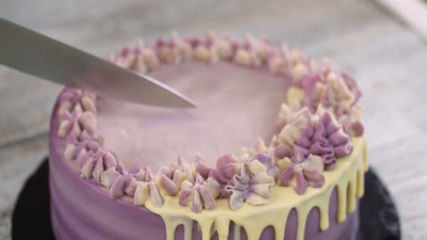 女人的手在木头底上用紫色奶油切蛋糕 紫色的蛋糕 顶部视图 — 图库视频影像