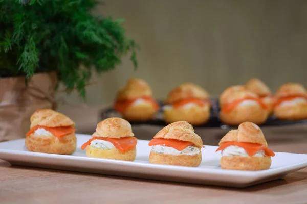 Ahşap arka planda somon ve krem peynir ile Profiteroles
