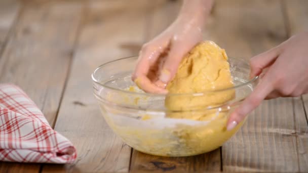 Les mains des femmes pétrissent la pâte sur une table . — Video