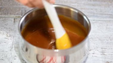 Bir tencerede şeker den karamel sos yapma süreci.