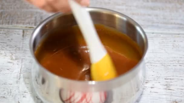 Η διαδικασία του να φτιάχνεις σάλτσα καραμέλας από τη ζάχαρη σε ένα κατσαρολάκι. — Αρχείο Βίντεο