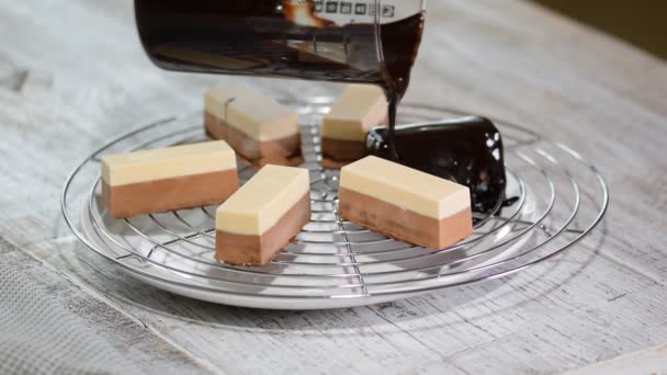 Konditor är dekorera mousse kakor med flytande choklad hälla den på toppen av kakan. — Stockvideo