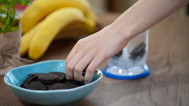 De vrouw deed chocoladekoekjes in de blender. Kookproces — Stockvideo