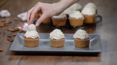 Hindistan cevizi frosting ile taze pişmiş vanilyacupcake. Hindistan cevizi truffles ile dekorasyon cupcakes