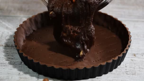 Pouring chocolate batter over top. Making Chocolate Tart. — Stock Video