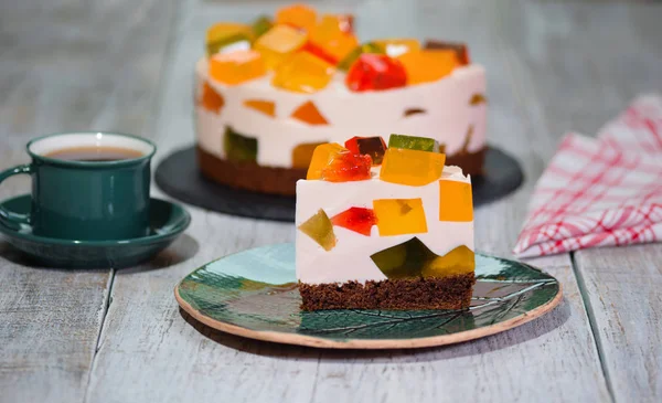 Кусок домашнего фруктового молочного многоцветного желейного торта на тарелке — стоковое фото