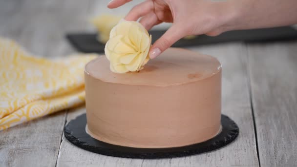 Baker chef met behulp van witte chocolade bloemen versieren chocolade taart — Stockvideo