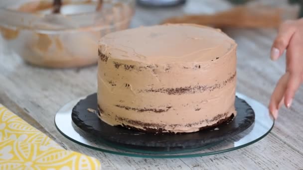 Young girl in an apron is cooking a chocolate cake — 비디오