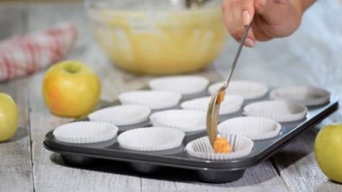 Elma ile hafif hamurdan cupcake pişirme. Kekler fırın tepsisine dökülür. Muffin pişirme yemeği içine hamur kek dökme.