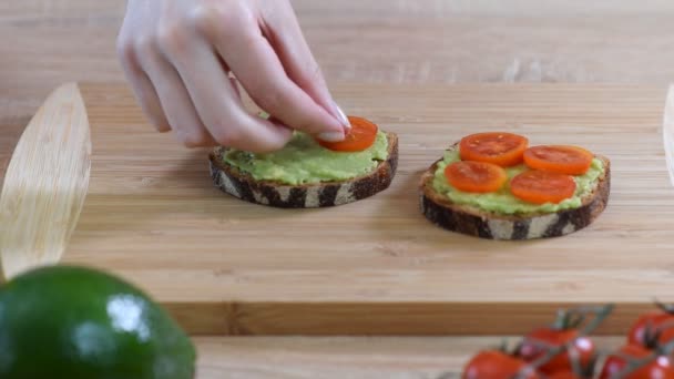 Cocinar bruschetta con queso crema, aguacate y tomates cherry . — Vídeos de Stock