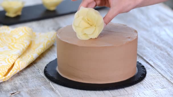 Σεφ φούρναρης χρησιμοποιώντας λευκή σοκολάτα λουλούδια διακόσμηση κέικ σοκολάτας. — Αρχείο Βίντεο