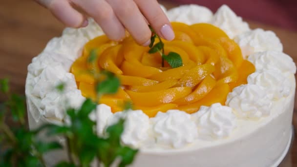 Випічка шеф-кухаря прикрашена м'ятою домашнього кремового персикового торта з м'ятою — стокове відео