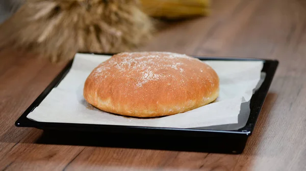 Vers gebakken brood op een bakplaat — Stockfoto