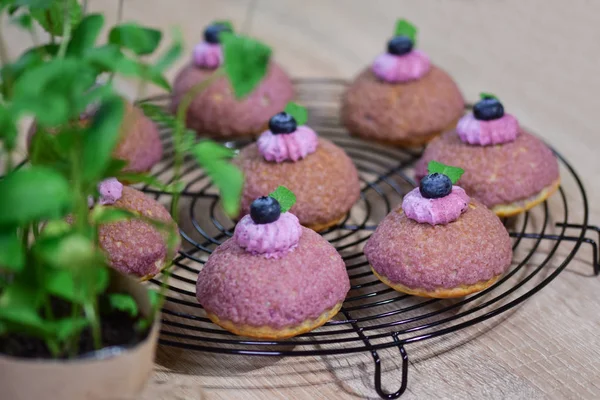 Bir yaban mersini krem ile dolu mor craquelin ile profiteroller. Krem puf choux tatlı