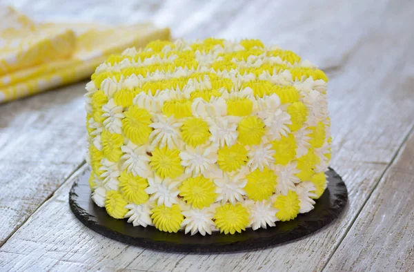 Pastel amarillo sentado en un puesto de pasteles. Hermoso pastel casero decorado con crema . — Foto de Stock