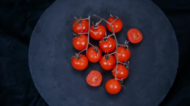 Čerstvé cherry rajčata na černém pozadí. — Stock video