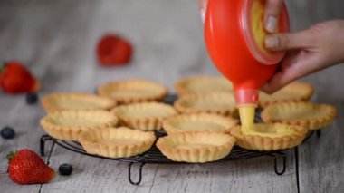 Kız tartlets muhallebi ile doldurur. Pasta. Tatlı tartlets tatlı