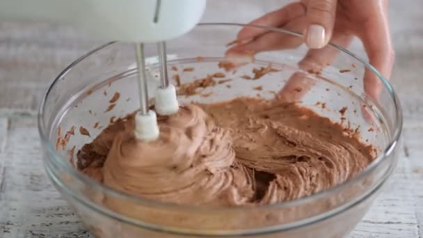 Mezclar la masa de chocolate en el recipiente de vidrio sobre el fondo blanco. Cocina casera — Vídeos de Stock