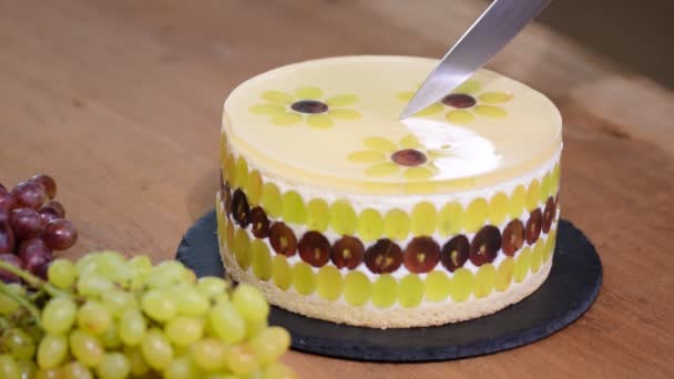 Vágás egy kést mousse torta szőlő. Szőlő díszített kerek mousse torta. — Stock videók