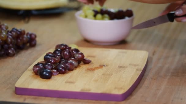 Uvas en rodajas de chef en una tabla de cortar — Vídeo de stock