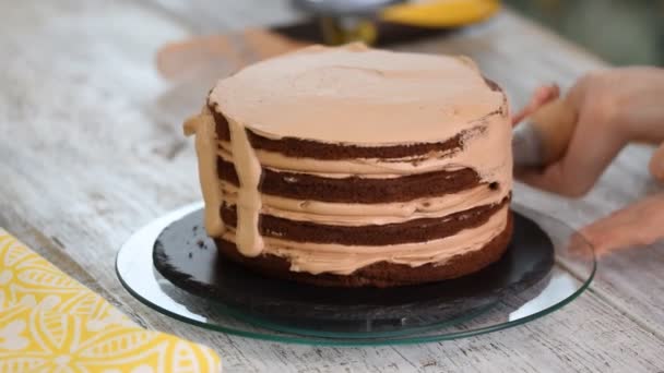 Crema que se aprieta en el pastel de chocolate. Apretando la crema en el pastel . — Vídeos de Stock