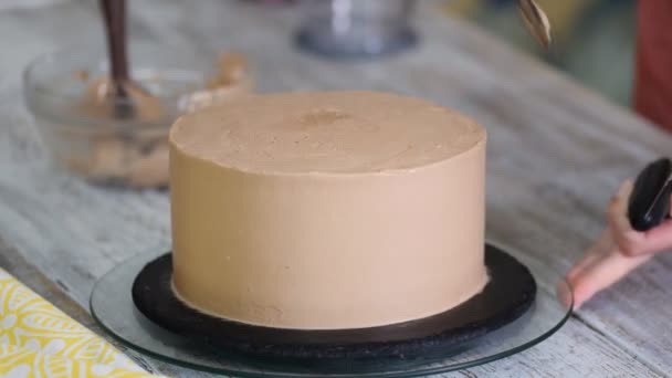 Sahne, die auf Schokoladenkuchen gepresst wird. Sahne auf den Kuchen drücken. — Stockvideo