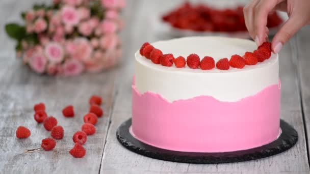 Cocinero pastelero en la cocina decorando un pastel con frambuesas . — Vídeos de Stock