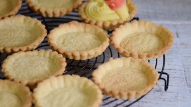Kız tartlets muhallebi ile doldurur. Pasta. Tatlı tartlets tatlı.