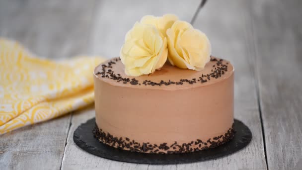 Corte de pastel de chocolate en el plato. Pastel de chocolate decorado flores de chocolate blanco . — Vídeos de Stock