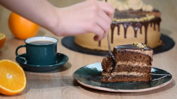 Att äta chokladkaka med en gaffel. Kvinna hand tar bett av kakan. Närbild Visa. — Stockvideo