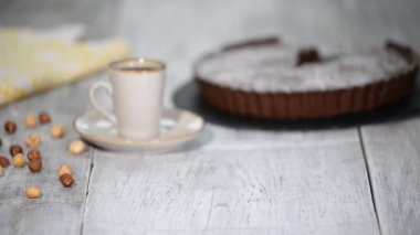 Beyaz ahşap arka plan üzerinde fındık ile ev yapımı çikolata tart
