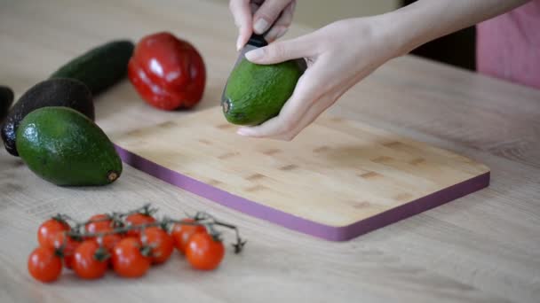 Plátkování čerstvého avokáda na dřevěné desce. — Stock video