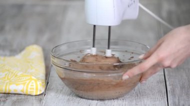 Kakao ile mikser çikolata hamuru kırbaçlama. Çikolata hamuru cam bir kapta bir mikser ile karıştırılır.