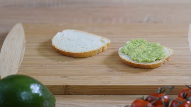 Rustik ahşap arka plan üzerinde avokado, kiraz domates ve keten tohumu ile Tost. Sağlıklı kahvaltı. — Stok video