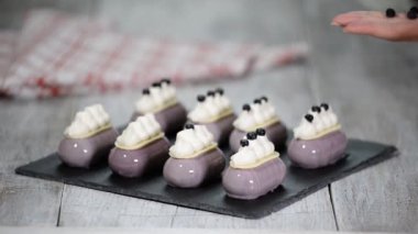 Şekerlemeci kek krem üzerinde yaban mersini bir tabaka yayılır