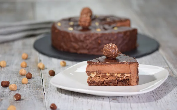 Bucată de tort delicios de ciocolată de casă pe farfurie, pe fundal deschis — Fotografie, imagine de stoc
