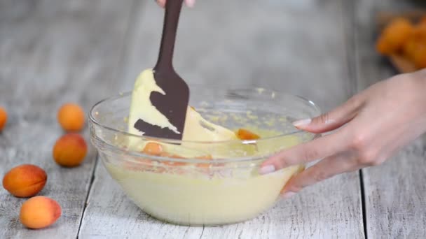 The hand mixers apricots with batter. Making apricots cake — Stock Video