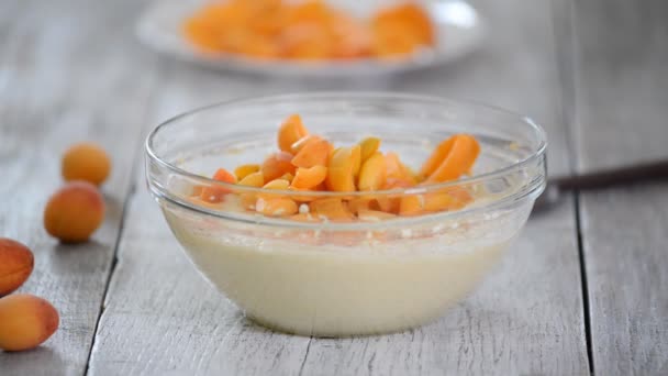 Chef add apricots to cake batter. The hand mix apricots with batter. Making apricots cake. — Stock Video