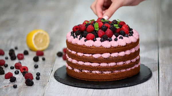 Pastel de chocolate con bayas sobre fondo de madera — Foto de Stock