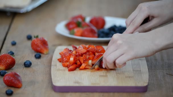 Close-up van de vrouw snijden aardbei in de keuken — Stockvideo