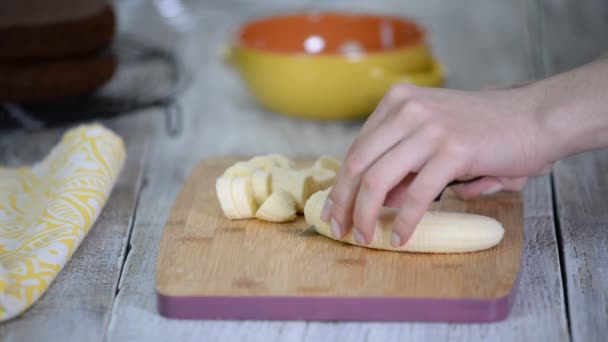 Primo piano sulla donna che taglia banana sul tagliere . — Video Stock