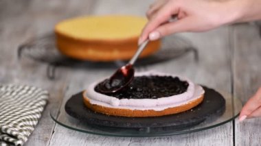 Taze yaban mersini ile pasta kek yapma ve dekorasyon. Bir şekerleme şırınga ile dekorasyon krem. Gıda endüstrisi.