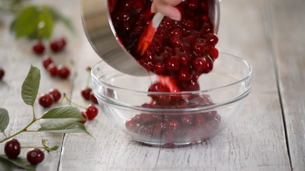 Verter el relleno de cereza en un recipiente de vidrio. Mujer haciendo pastel de cereza en la cocina — Vídeo de stock