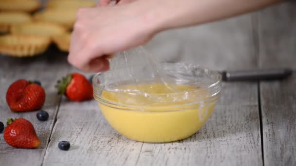 Woman whip the custard with a whisk. — Stock Video