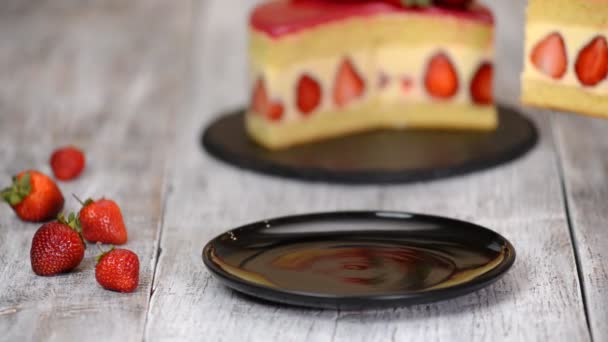 Strawberry cake Fraisier. A piece of strawberry cake in white plate on the wooden table — Stock Video