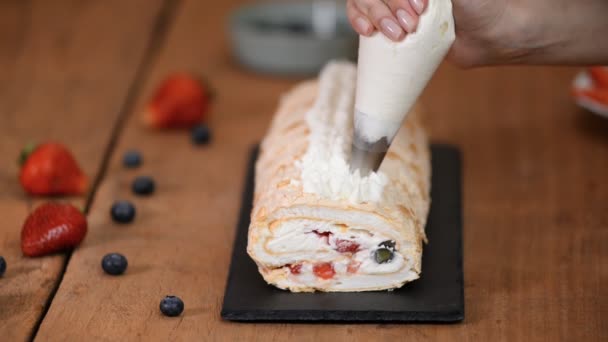 Process of making meringue roulade with summer berries. — Stock Video